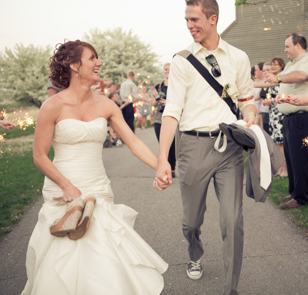 Candid bride and groom leaving wedding reception.