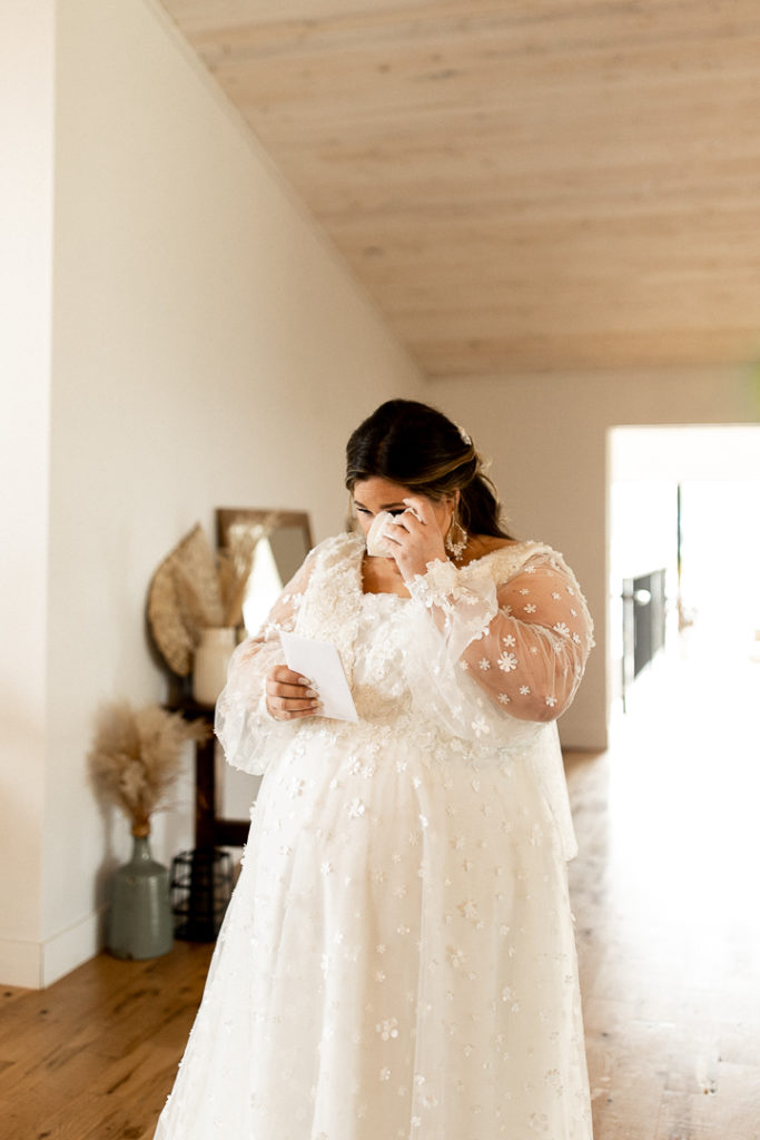 Bride spills tears as she continues reading letter from her groom. 