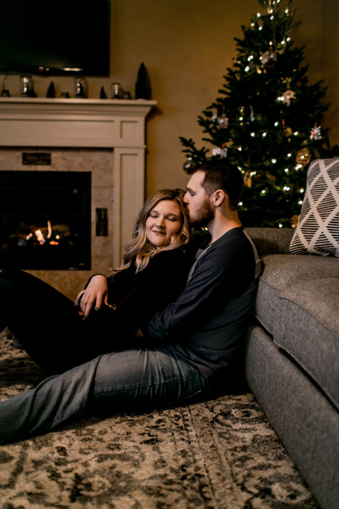 Lifestyle couple cuddling in front of fire in their home.