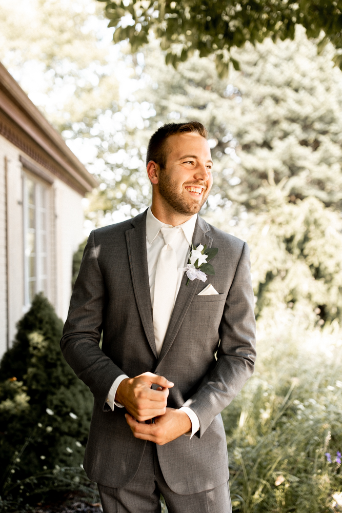 Groom flashes a big smile as he completes his appearance before seeing his bride for the first time.