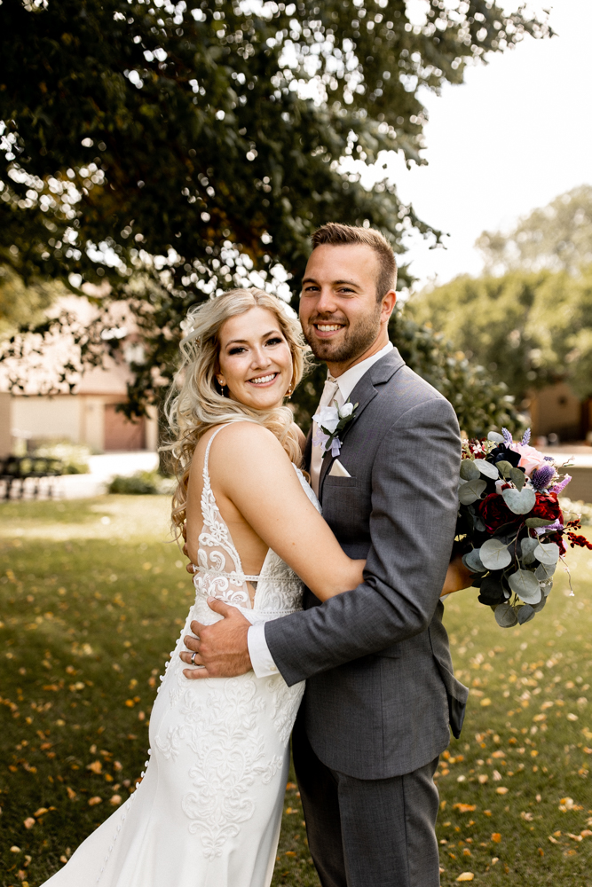 Bride and groom show off gorgous smiles radiating pure joy and love on their wedding day.