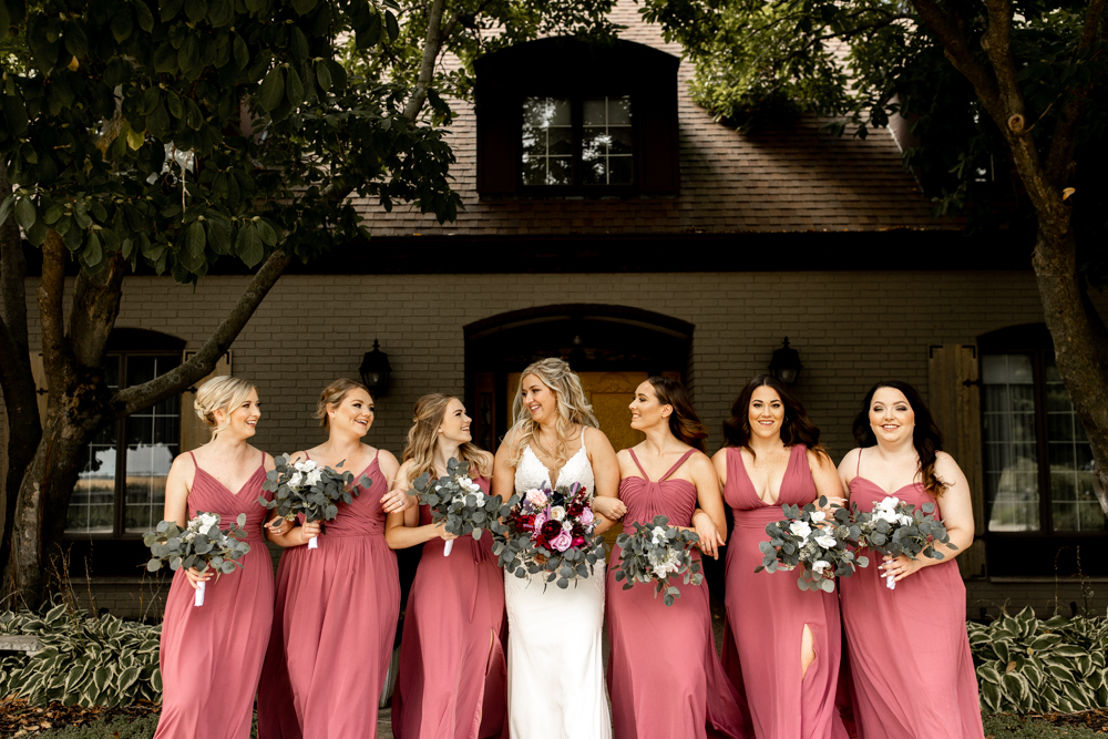 Candid photo of bride laughing and conversing with her bridesmaids. 