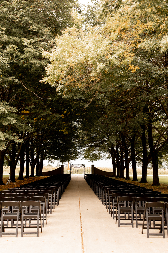 Gorgeous outdoor wedding venue - The Conrad Mansion, in Iowa. Stunning colorful trees hang over the ceremony space. 