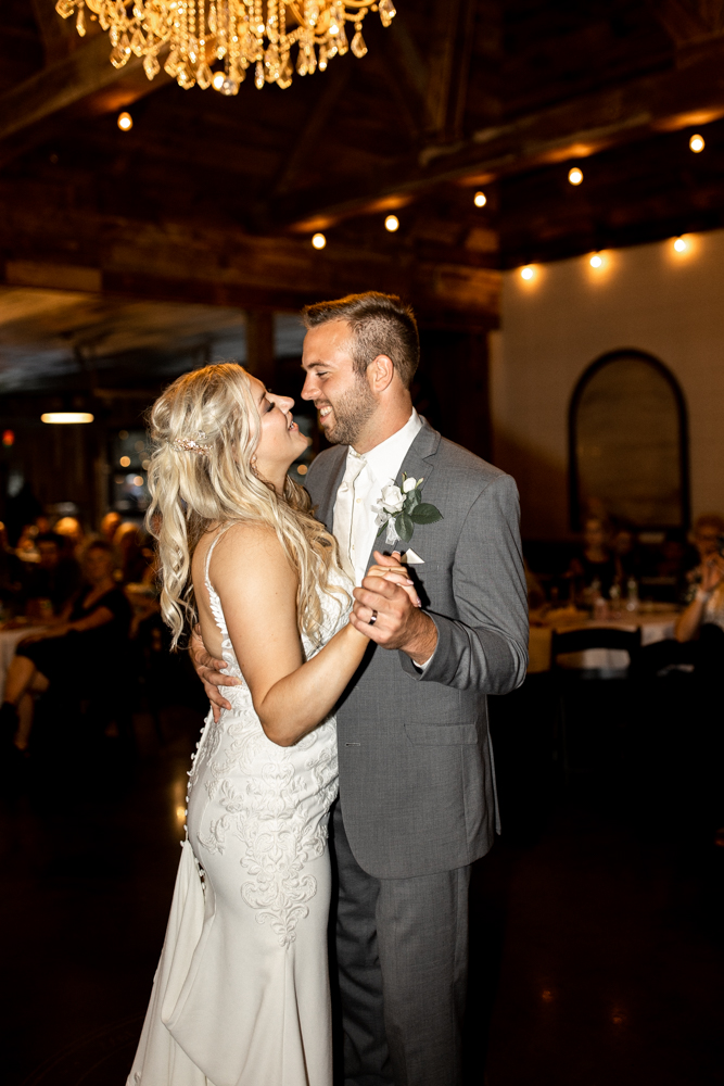 Husband and wife share a happy smile during their first dance together following their beautiful wedding day.