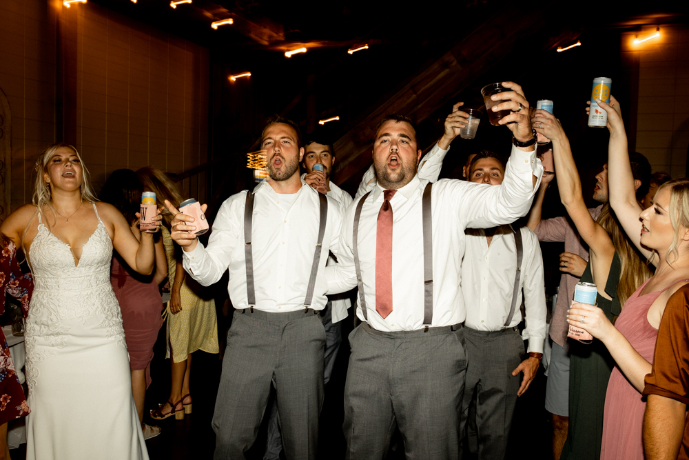 Groom and his groomsmen sing and dance with the song as wedding reception carries on.
