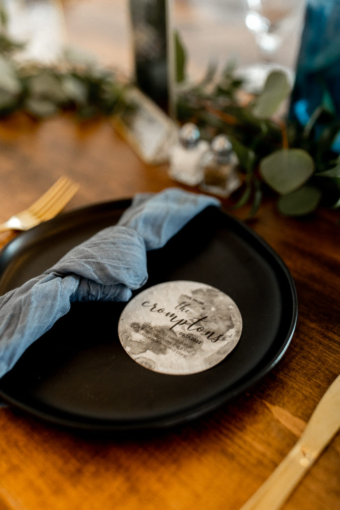 Plates decorated with moon details card and gorgeous knotted blue napkins. Decor and details captured by Iowa Wedding Photographer. 