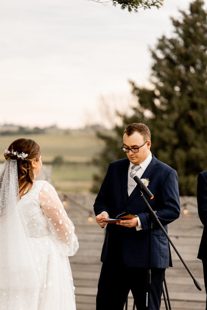 Groom reads bride his vows he has written for her on their wedding day. 
