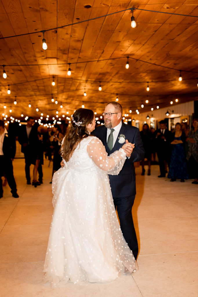 Bride and her dad share a dance as they talk about the beauty of the wedding day. 