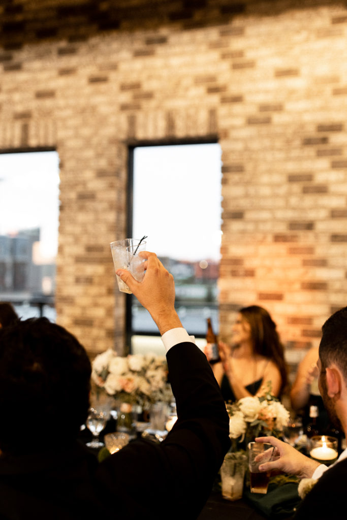 Drinks are raised in the air as a cheers follows wedding speeches for the newlyweds! 