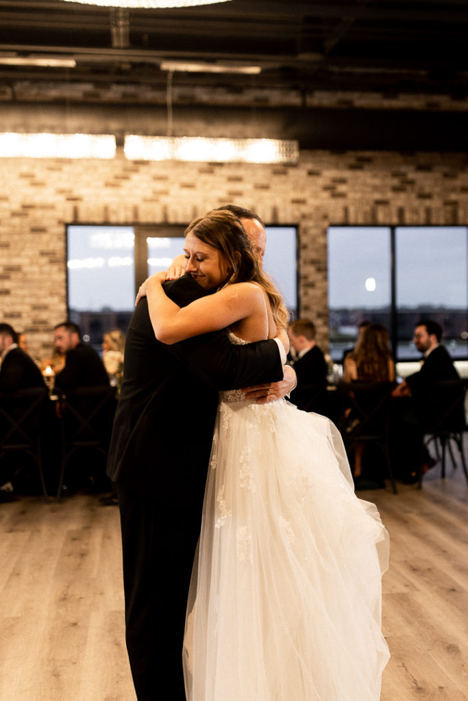 Following father daughter dance, bride and her dad share a big embrace. Memories that this bride and her dad will hold onto forever captured by Midwest Wedding Photographer. 