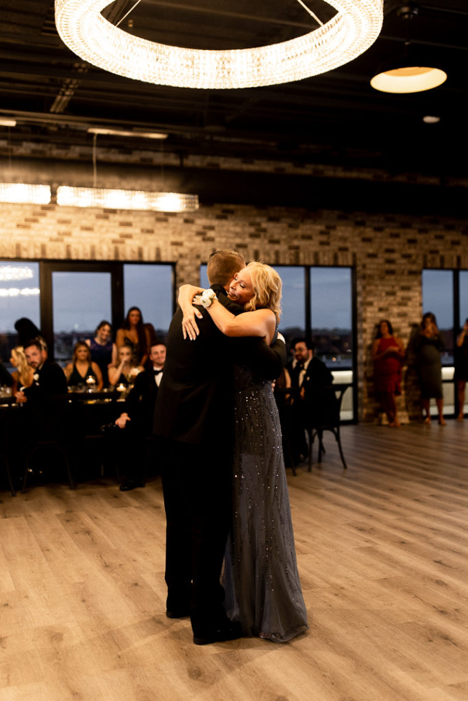Mom and son share a hug following their dance together. Moments treasured forever captured by DSM Iowa Wedding Photographer. 