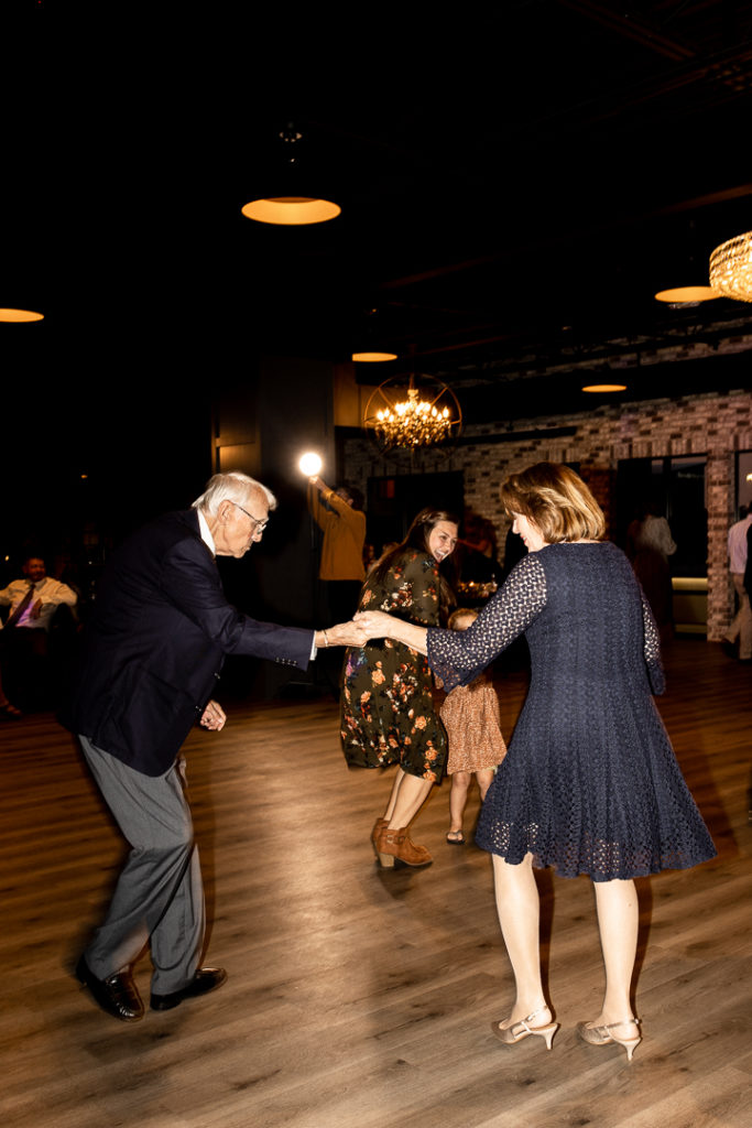 Guests dance on the dance floor of Iowa Wedding Reception at event venue Toast in Ankeny. Such a fun Iowa Wedding Day celebrated with the bride and groom and all of their guests! 