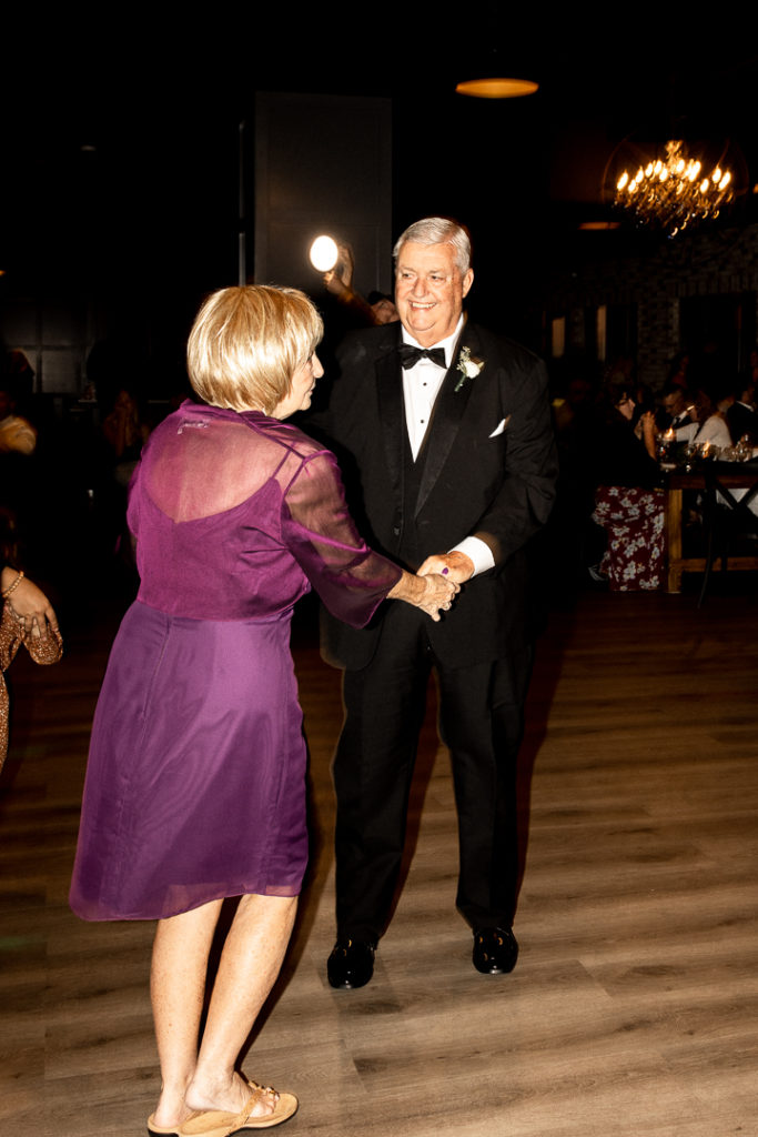 Guests dance on the dance floor of Iowa Wedding Reception at event venue Toast in Ankeny. Such a fun Iowa Wedding Day celebrated with the bride and groom and all of their guests! Moments to treasure forever, captured by Des Moines Wedding Photographer. 