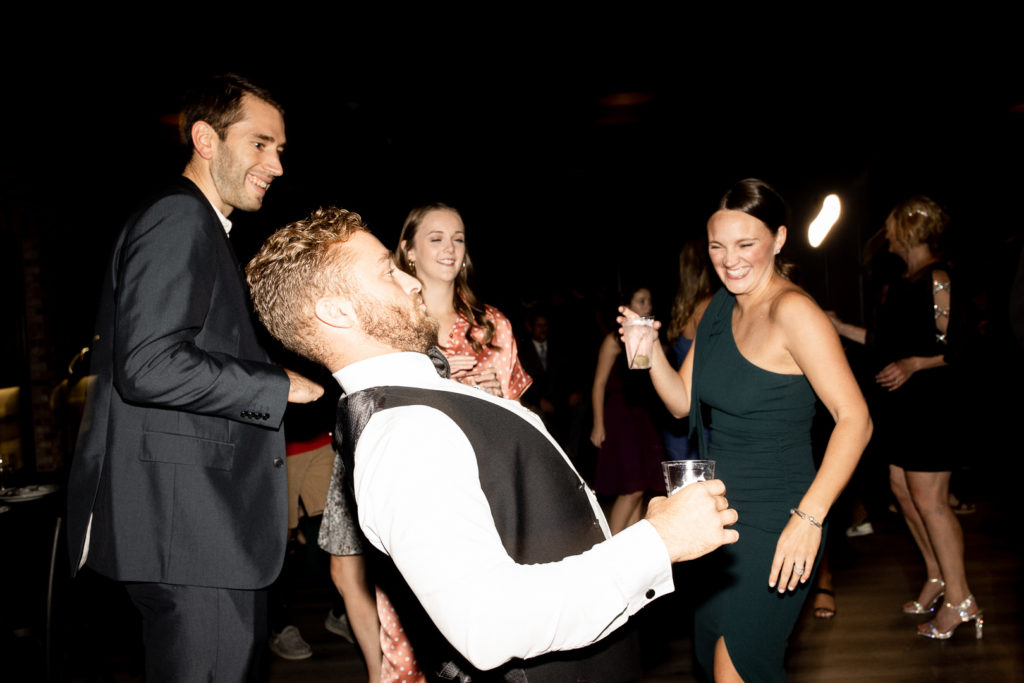Members of the bridal party let loose and have some fun on the dance floor at the wedding reception celebrating their friends wedding day! Gorgeous Des Moines Wedding Venue and moments captured by Iowa Wedding Photographer. 