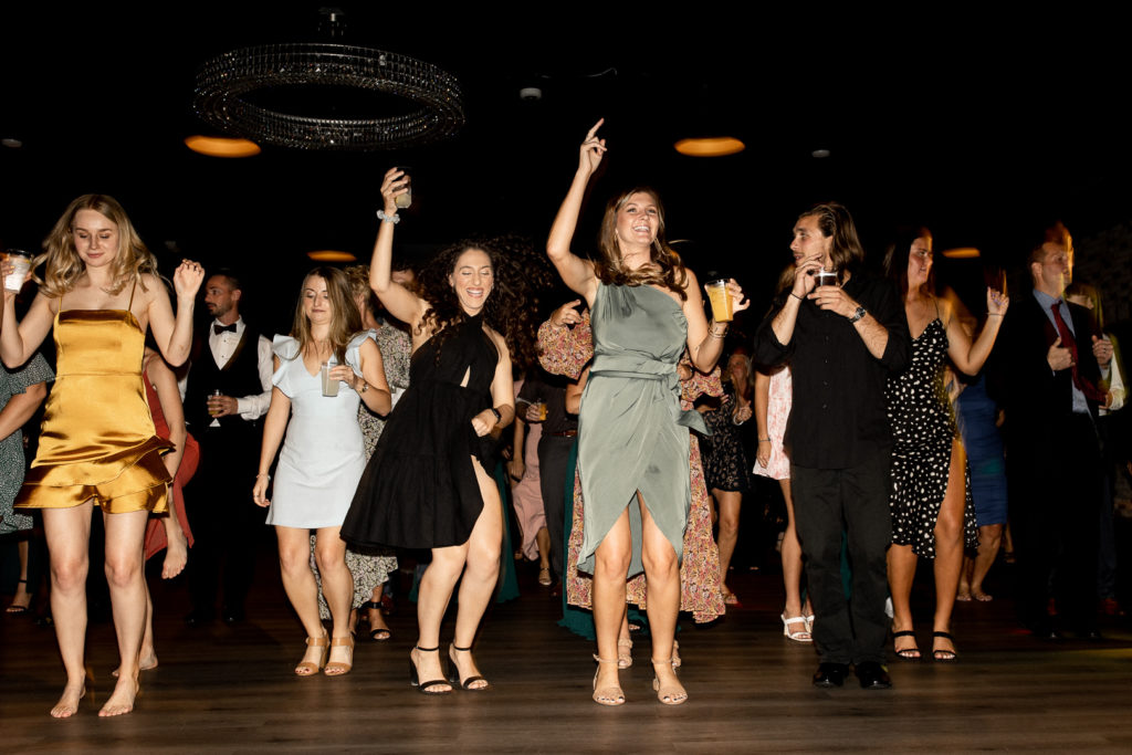 Members of the bridal party and more friends and familylet loose and have some fun on the dance floor at the wedding reception celebrating their friends wedding day! Gorgeous Des Moines Wedding Venue and moments captured by Iowa Wedding Photographer. 