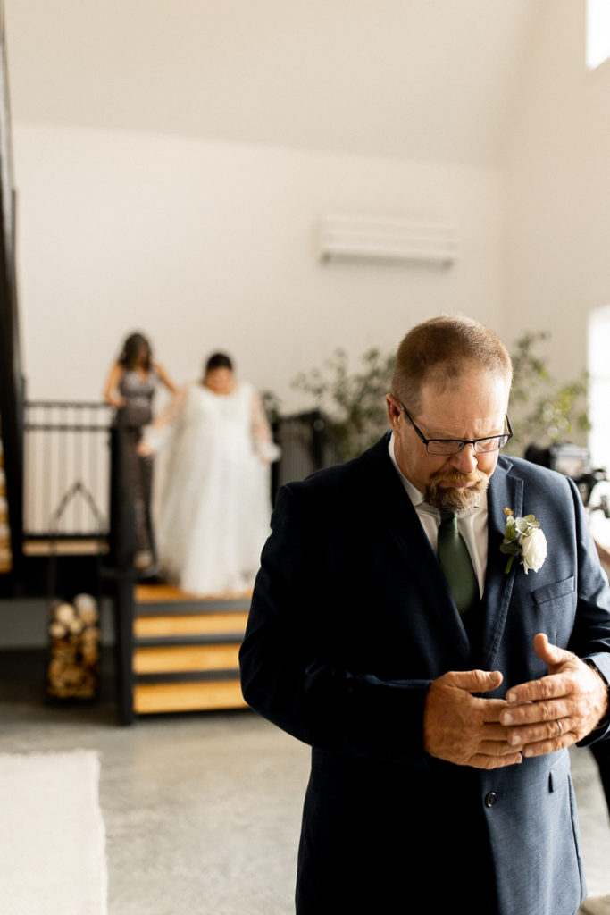 Bride is escorted down the stairs by her mom as she is moments away from sharing a first look with her dad. Precious moments and captured memories by Iowa Wedding and Lifestyle Photographer. 