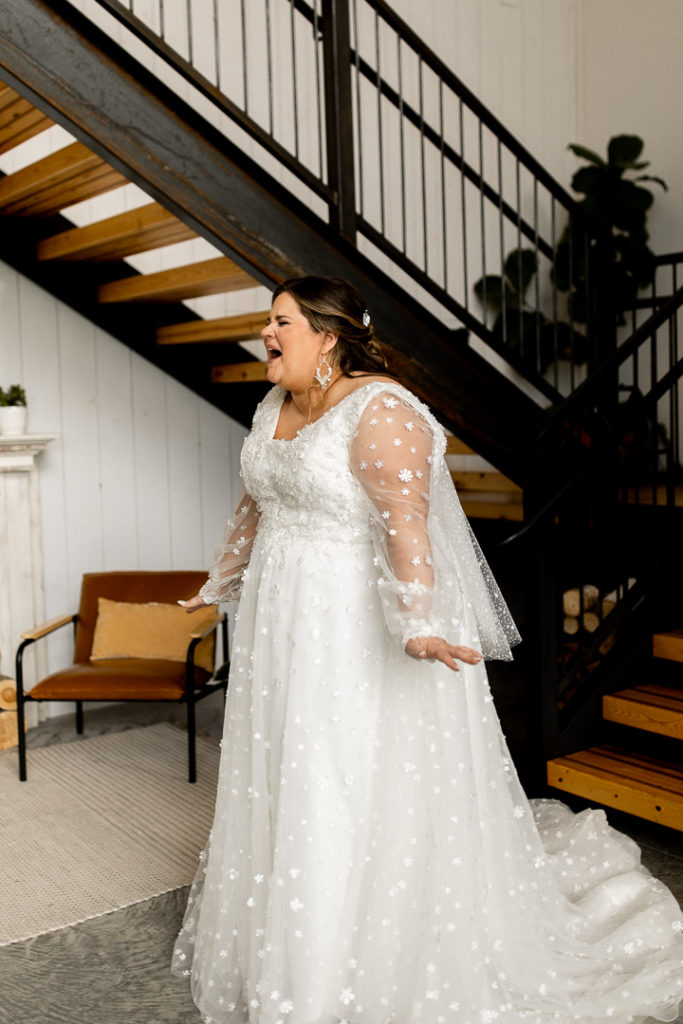 Bride smiles in pure joy and excitement before she shares first look with her dad. 