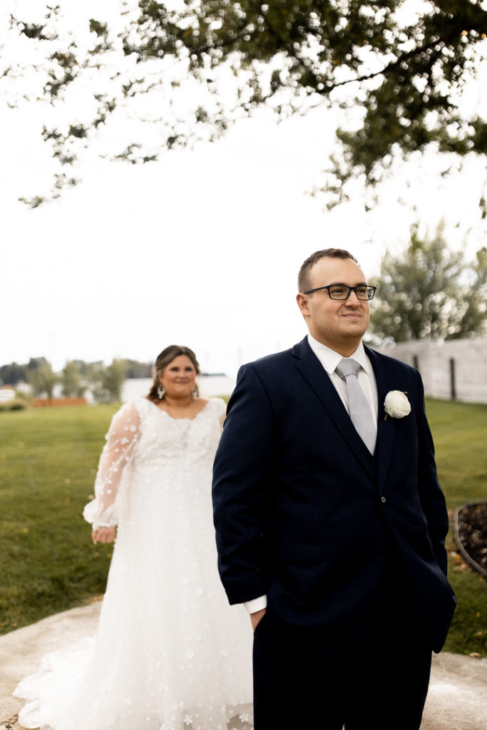Bride is standing feet away from her groom, behind him, just moments before their first look. 