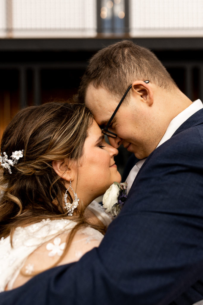 More posed photos from the wedding photographer of the newly married couple! Husband and wife rest their foreheads on each other's and give soft smiles as their eyes are closed. 